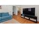 Living room showing hardwood floors, blue couch, TV with sleek media center at 414 W Markham Ave, Durham, NC 27701