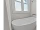 Modern freestanding bathtub with sleek lines and a window above, creating a spa-like retreat and modern fixtures at 414 Wyndham Dr, Chapel Hill, NC 27516