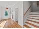 Bright entryway with hardwood floors, wooden stairs, and white trim, showcasing a welcoming ambiance and functional design at 414 Wyndham Dr, Chapel Hill, NC 27516