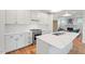 Modern kitchen with white cabinets, stainless steel appliances, quartz countertops and an island with a sink at 414 Wyndham Dr, Chapel Hill, NC 27516