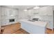 Bright kitchen features white cabinets, subway tile backsplash, and a large center island with marble countertops at 414 Wyndham Dr, Chapel Hill, NC 27516