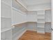 Spacious walk-in closet with multiple shelves and rods, offering practical storage solutions and hardwood floors at 414 Wyndham Dr, Chapel Hill, NC 27516