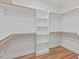 Well-organized walk-in closet with custom shelving and wooden rods, providing ample storage space and hardwood floors at 414 Wyndham Dr, Chapel Hill, NC 27516