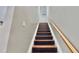 View of the staircase with black treads and light stained wood handrail at 4736 Walden Pond Dr, Raleigh, NC 27604