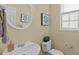 Cozy half bathroom with pedestal sink, toilet, and neutral wall color at 4804 Carmen Ln, Durham, NC 27707