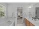Bathroom featuring a soaking tub, double vanity, and an open view into the bedroom at 4804 Carmen Ln, Durham, NC 27707
