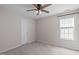 Comfortable bedroom features a ceiling fan, a window and plush carpet, creating a warm retreat at 4804 Carmen Ln, Durham, NC 27707