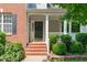 Charming front porch with brick steps, white railing, and neatly trimmed shrubbery at 4804 Carmen Ln, Durham, NC 27707
