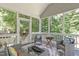Relaxing screened porch with cozy seating area and wooded views to extend living space outdoors at 4804 Carmen Ln, Durham, NC 27707