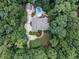 Aerial view of beautiful home surrounded by lush green trees, sparkling blue pool, and garden at 5005 Lenoraway Dr, Raleigh, NC 27613