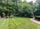 Well-manicured backyard with lush lawn and mature trees, offering a private outdoor space at 5005 Lenoraway Dr, Raleigh, NC 27613