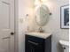 Bathroom featuring a navy vanity with a modern sink, a round mirror, and updated fixtures at 5005 Lenoraway Dr, Raleigh, NC 27613