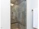 Tiled shower stall featuring decorative accents, glass door and brushed metal handle at 5005 Lenoraway Dr, Raleigh, NC 27613