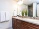 Bathroom featuring large mirror above dual sink vanity with shaker cabinets and tiled shower at 5005 Lenoraway Dr, Raleigh, NC 27613