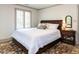 Bedroom with white bedspread, bedside table with lamp, plantation shutters, and area rug at 5005 Lenoraway Dr, Raleigh, NC 27613