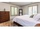 Bright bedroom featuring a white bedspread, dark dresser, windows with shutters, and area rug at 5005 Lenoraway Dr, Raleigh, NC 27613