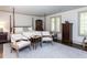 Spacious bedroom with neutral rug, decorative window, and seating area around white chairs at 5005 Lenoraway Dr, Raleigh, NC 27613