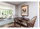 Cozy dining area with dark wood table and chairs, adjacent to a sunlit living room at 5005 Lenoraway Dr, Raleigh, NC 27613