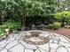 Outdoor stone firepit with flagstone surround and chair seating at 5005 Lenoraway Dr, Raleigh, NC 27613