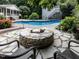 Outdoor living area with stone firepit, stone pavers and lush landscaping at 5005 Lenoraway Dr, Raleigh, NC 27613