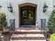 Elegant front entrance with double doors, brick steps, and decorative lighting at 5005 Lenoraway Dr, Raleigh, NC 27613