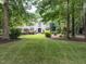 Stately home with well manicured front lawn, brick pathway, mature trees, and elegant landscaping at 5005 Lenoraway Dr, Raleigh, NC 27613