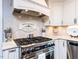 Well appointed kitchen features a gas range and hood, marble backsplash, and designer touches at 5005 Lenoraway Dr, Raleigh, NC 27613