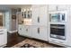 Elegant kitchen with white cabinetry, stainless steel appliances, and dark hardwood floors at 5005 Lenoraway Dr, Raleigh, NC 27613