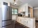 Well-lit kitchenette featuring white cabinets, granite countertops, and stainless steel refrigerator at 5005 Lenoraway Dr, Raleigh, NC 27613