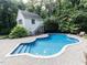 In-ground pool featuring a baja shelf, pool house and stone paver surround at 5005 Lenoraway Dr, Raleigh, NC 27613