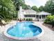 Backyard inground pool flanked by a brick home, screened porch and lush landscaping at 5005 Lenoraway Dr, Raleigh, NC 27613