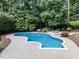 Backyard shot of inground pool surrounded by lush landscaping and stone pavers at 5005 Lenoraway Dr, Raleigh, NC 27613