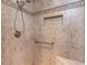 Tiled shower featuring tiled walls, recessed storage space, safety bar, and a shower head at 5005 Lenoraway Dr, Raleigh, NC 27613