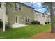Backyard featuring green grass, a small patio, and an AC unit along a townhome at 507 Brier Crossings Loop, Durham, NC 27703