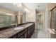 Bathroom featuring double sinks, dark wood cabinets, and a glass-enclosed shower at 507 Brier Crossings Loop, Durham, NC 27703