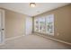 Neutral carpeted bedroom featuring a window with blinds and a closet at 507 Brier Crossings Loop, Durham, NC 27703