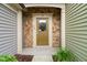 A well-lit entryway with a stylish front door, stone accents, and verdant greenery at 507 Brier Crossings Loop, Durham, NC 27703