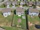 Backyard includes green lawn, a patio, a fire pit, and recreational area surrounded by a wooden fence in a residential neighborhood at 525 Willow Breeze Ct, Zebulon, NC 27597