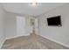 This carpeted bedroom has a mounted television and access to another room at 525 Willow Breeze Ct, Zebulon, NC 27597
