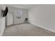 A well-lit bedroom features neutral carpet, a large mirror, and a mounted television at 525 Willow Breeze Ct, Zebulon, NC 27597