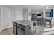 A kitchen island with bar stool seating overlooks the dining area and living room, offering a modern and open living space at 525 Willow Breeze Ct, Zebulon, NC 27597