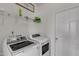 Functional laundry room equipped with a modern washer and dryer, plus storage shelving and a door at 525 Willow Breeze Ct, Zebulon, NC 27597