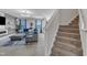 Spacious living room showcasing cozy seating, elegant lighting, and access to the upper level via the staircase at 525 Willow Breeze Ct, Zebulon, NC 27597