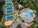 Stunning aerial view of a community pool and tennis courts surrounded by lush greenery, offering a resort-like experience at 5309 Overtop Ln, Raleigh, NC 27613