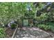 Backyard patio area with decorative panels, lush greenery, and colorful flowers, perfect for relaxation at 5309 Overtop Ln, Raleigh, NC 27613