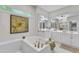 Bright bathroom with double vanity, soaking tub, and stylish decor at 5309 Overtop Ln, Raleigh, NC 27613
