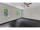 Bedroom with ceiling fan features two large windows and dark floors at 5309 Overtop Ln, Raleigh, NC 27613