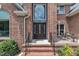 Elegant brick home featuring a beautiful front door and meticulously maintained landscaping at 5309 Overtop Ln, Raleigh, NC 27613