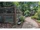 Backyard featuring a wood greenhouse, gravel path, and mature trees, creating a serene garden space at 5309 Overtop Ln, Raleigh, NC 27613