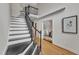 Elegant staircase featuring hardwood floors and a black railing, leading to the upper level at 5309 Overtop Ln, Raleigh, NC 27613